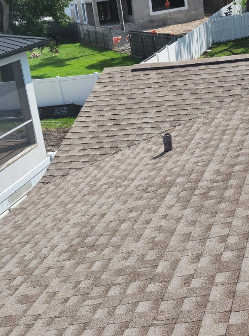 A close view of a shingle roof and roof vent